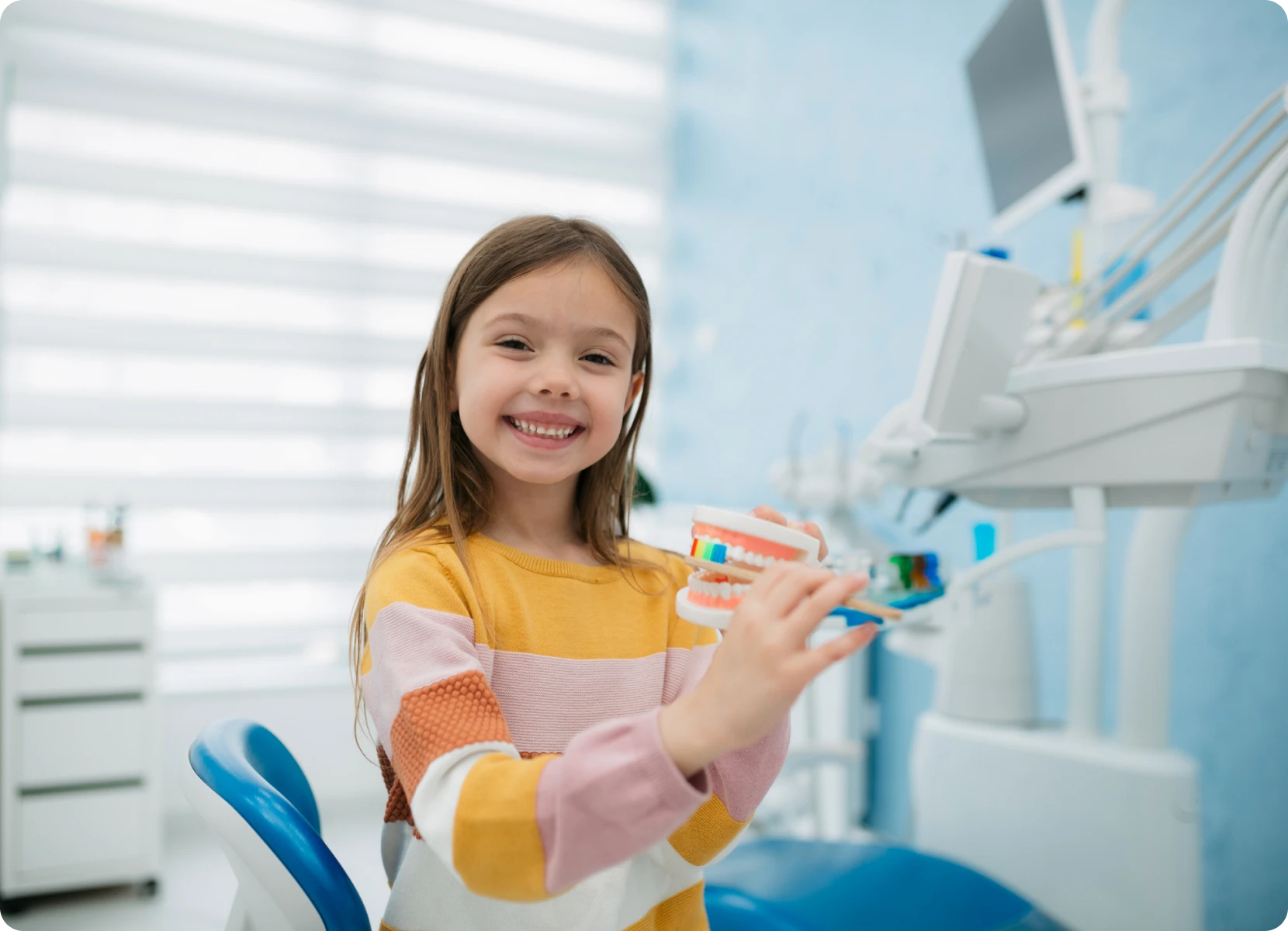 Young girl with toothbrush, dentist visit