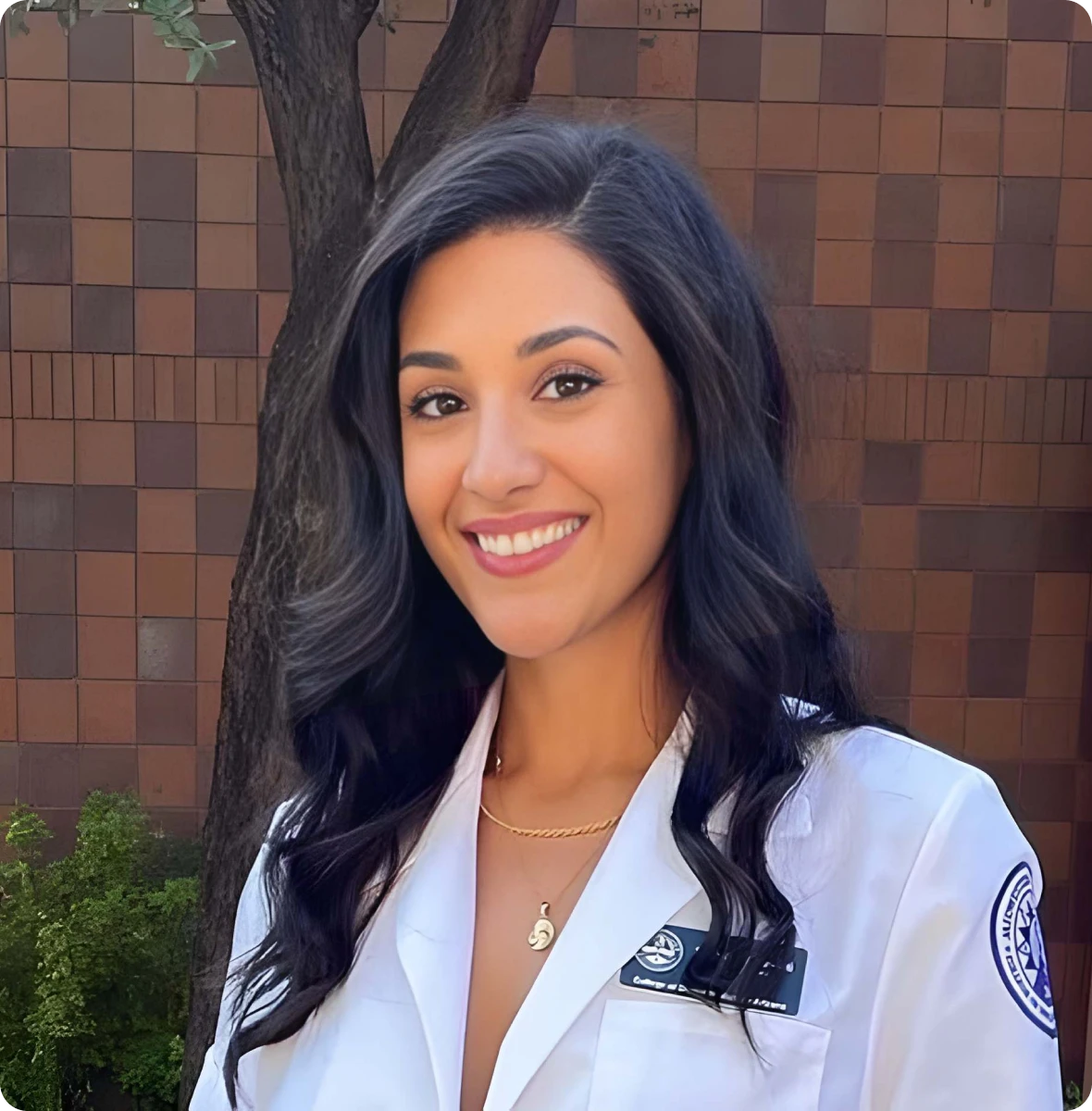 Smiling woman in medical attire outdoors