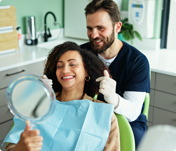 Patient smiling in dental chair with mirror